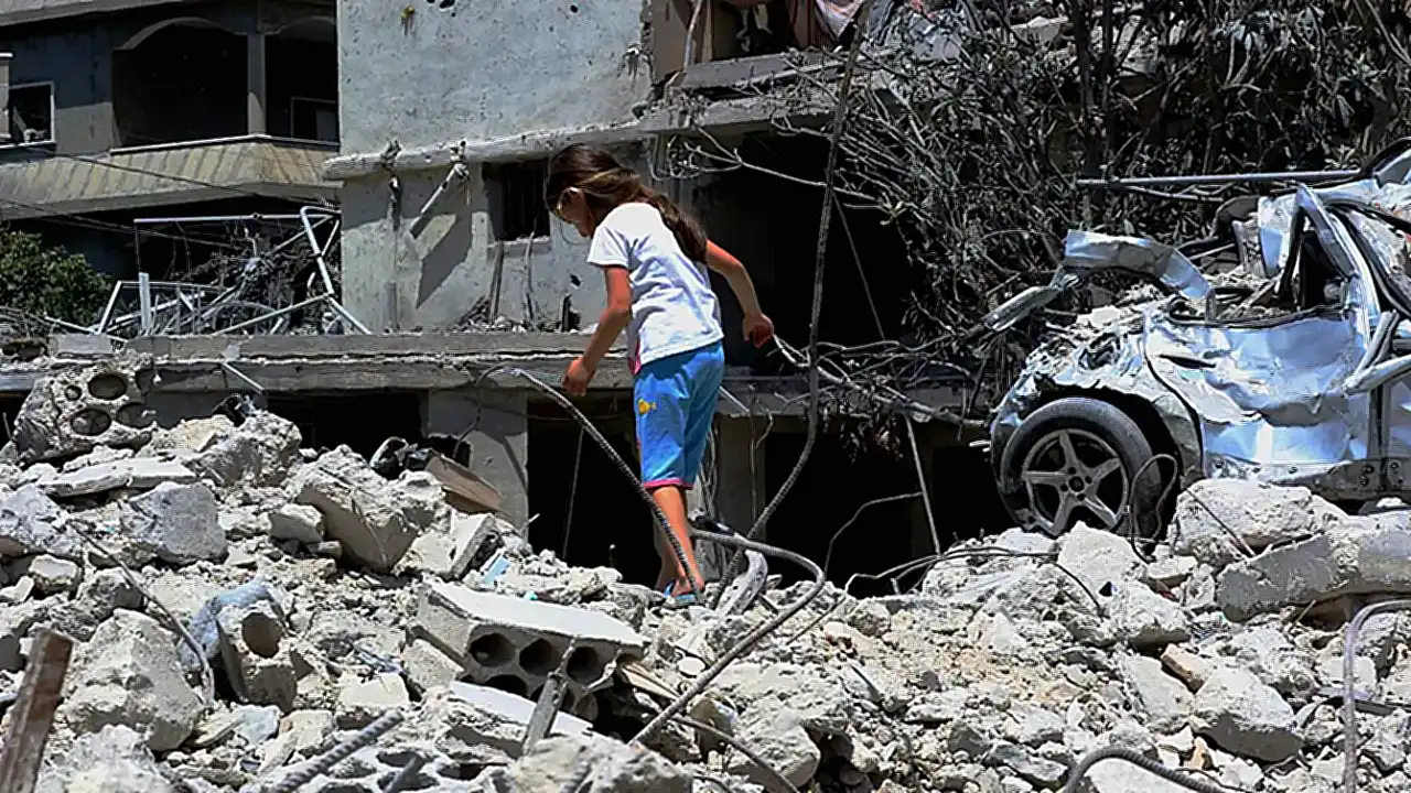 جنوب لبنان فتاة نازحة تمشي فوق منزل عائلتها المدمر في دير